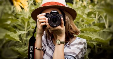 Photographer holding a DSLR camera in a sunflower field
